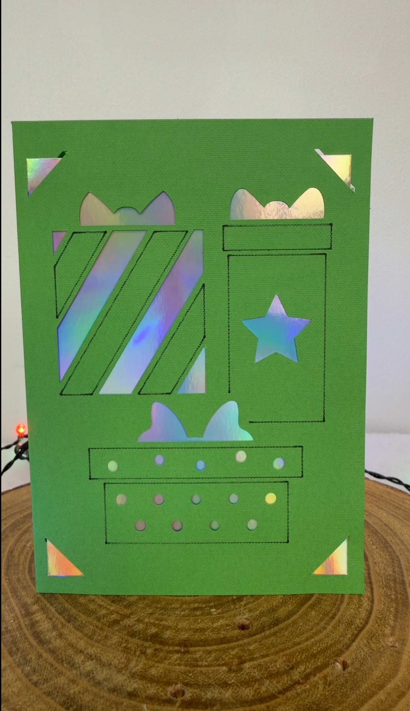 Green card with cut-out patterns on a wooden surface