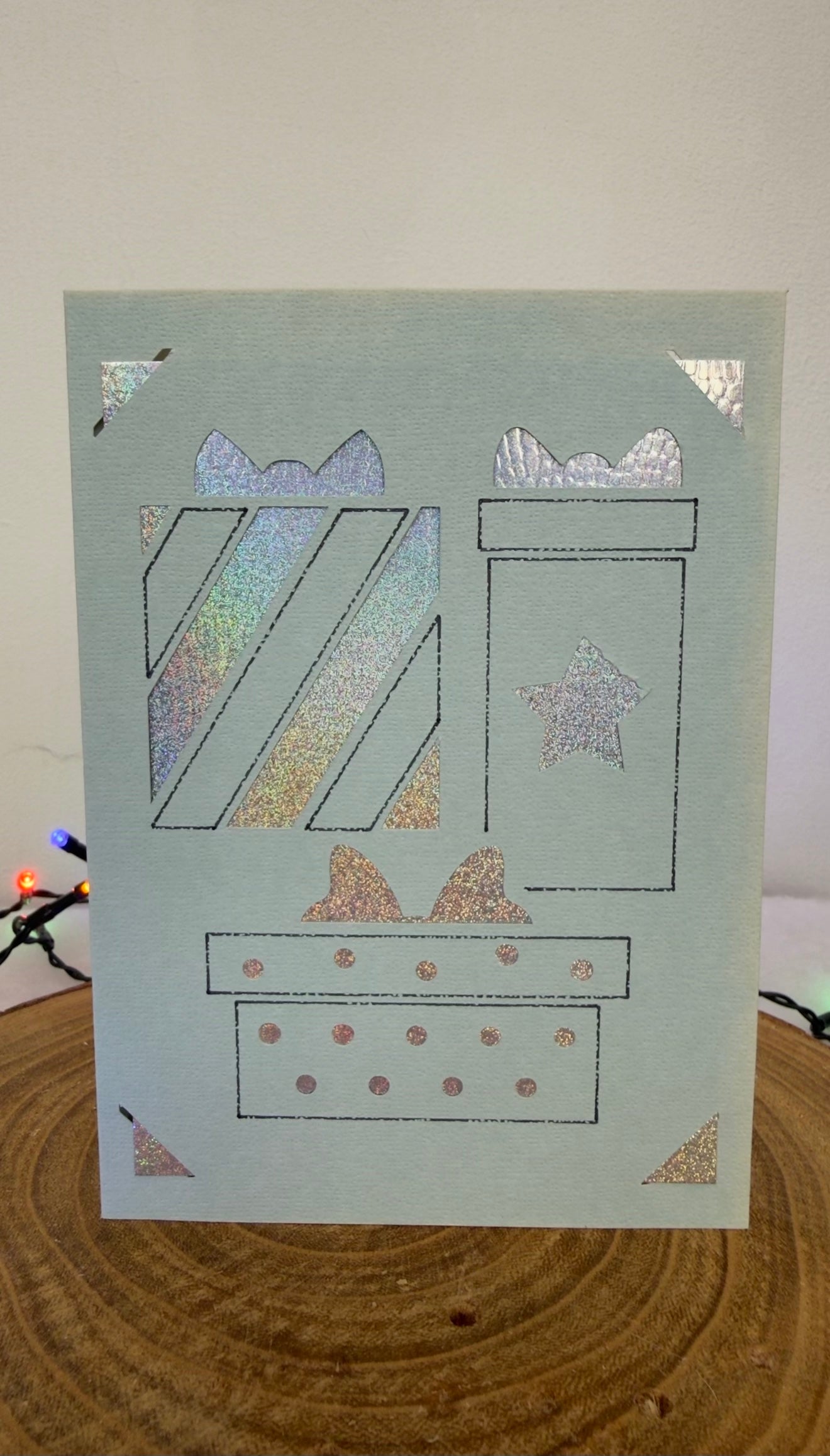 Card with decorative gift boxes on a wooden surface