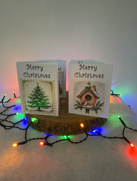 Two Christmas cards with festive designs on a wooden stand surrounded by colorful lights.