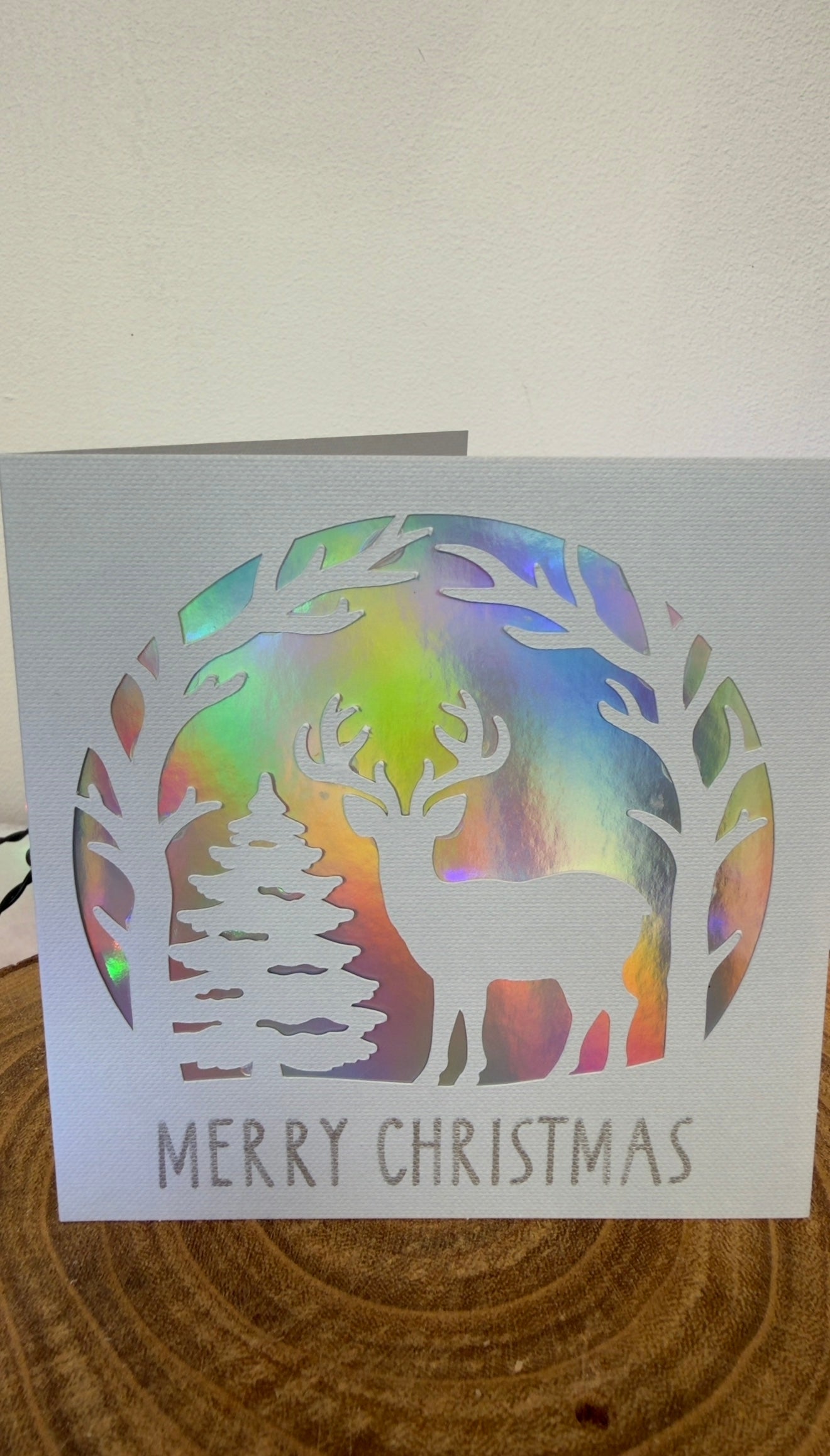 Christmas card with reindeer and rainbow design on a white background