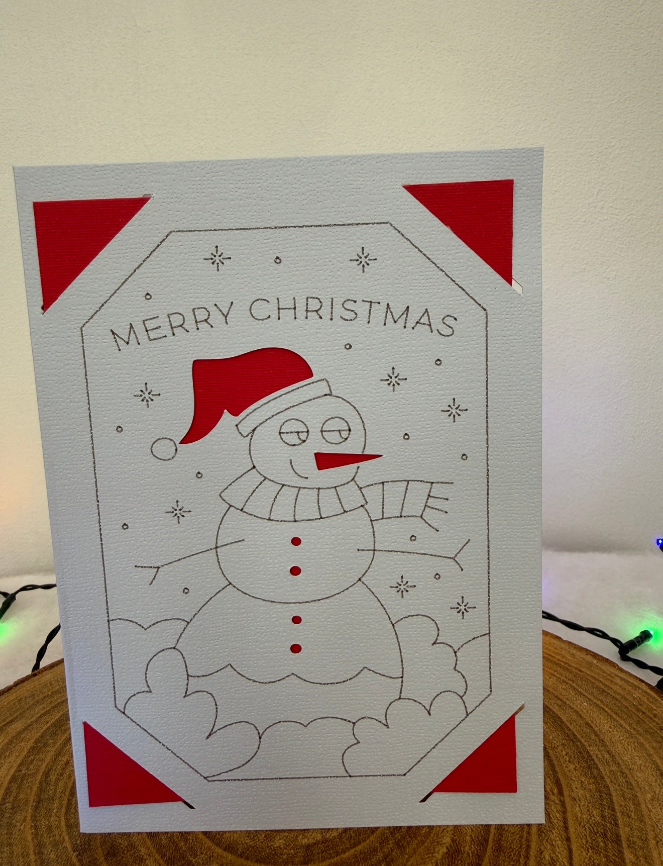 Christmas card with a snowman design and 'Merry Christmas' text on a white background.