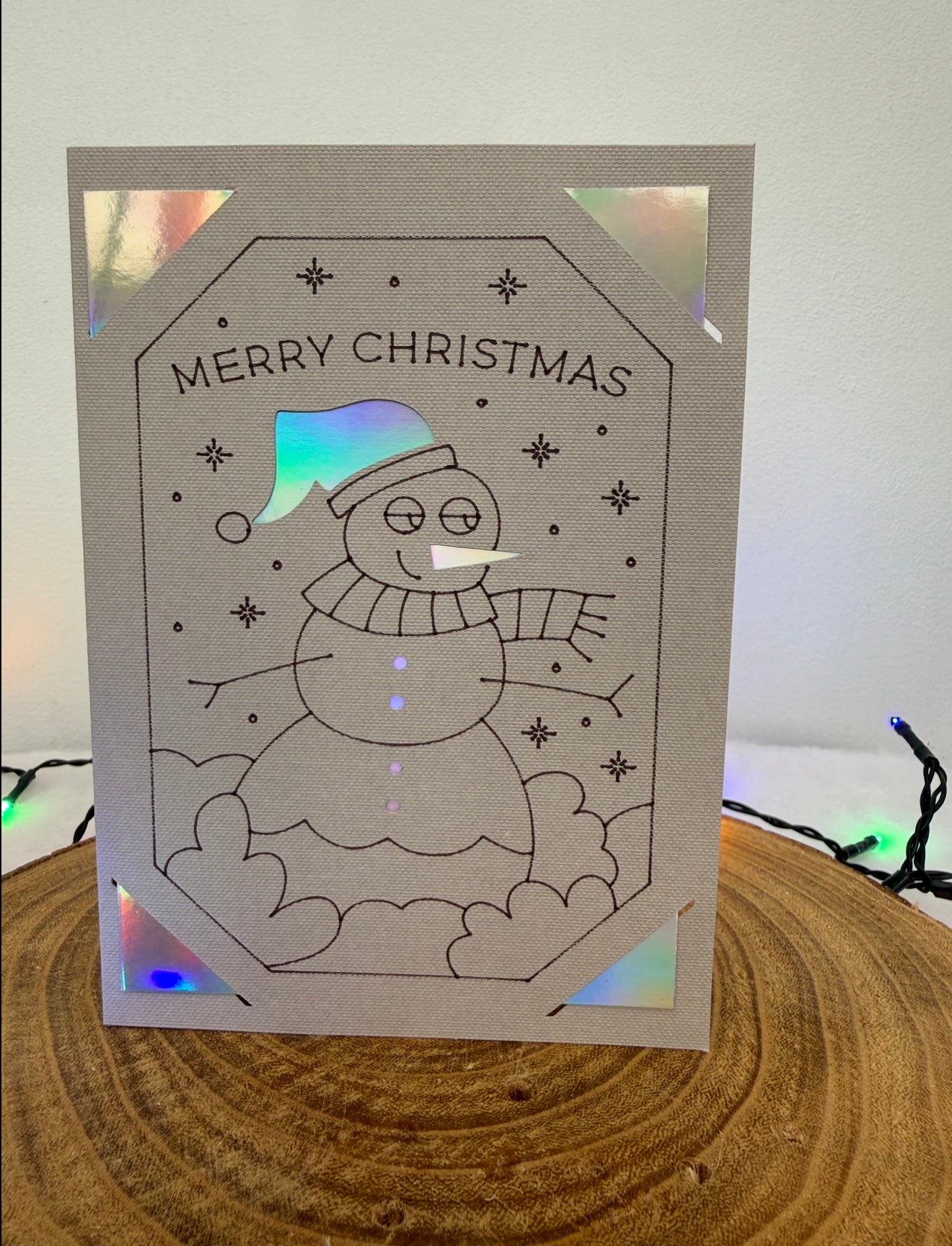 Christmas card with a snowman design and 'Merry Christmas' text on a white background.